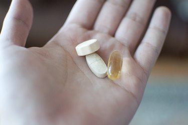 hand holding vitamin pills that might change urine color