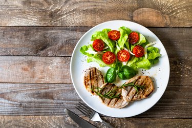 Barbecue pork with vegetables on wooden background