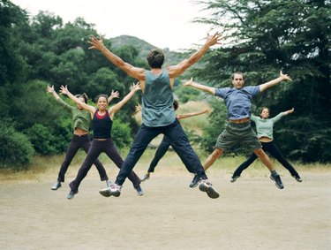 People doing jumping jacks in a park