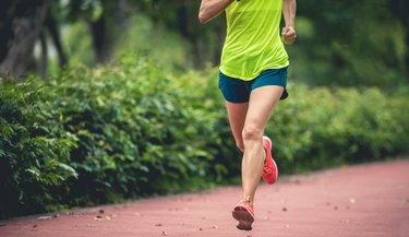 Fitness sporty woman jogger running at outdoors jogging track in park