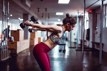 Female Doing Dumbbell Exercises In Gym