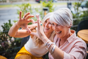 Smiling mature women making heart shape with fingers