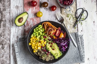 Quinoa veggie bowl of avocado, Edamame, tomatoes, corn, carrots, red cabbage and pomegranate seed