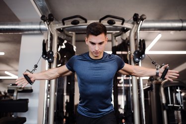 A young handsome man doing chest workout in the gym.