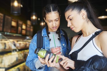 Two people examining ingredient list on juice bottle