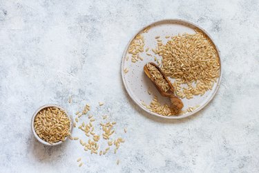 Brown rice in a wooden bowl with a  spoon