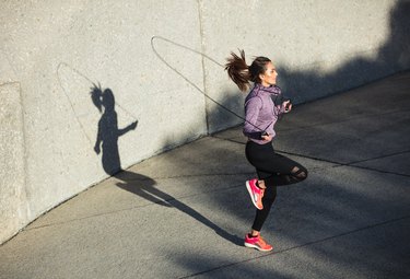 Healthy woman skipping ropes outdoors