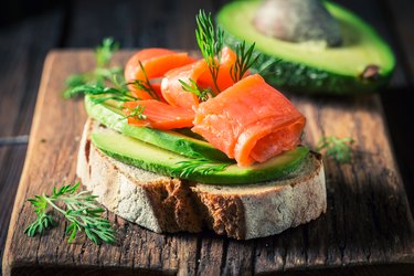 Closeup of sandwich with avocado, salmon and dill