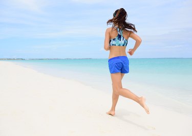Runner training cardio running on beach