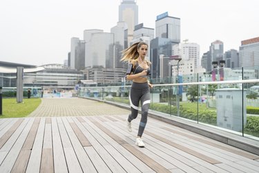 Blond sportswoman running on bridge