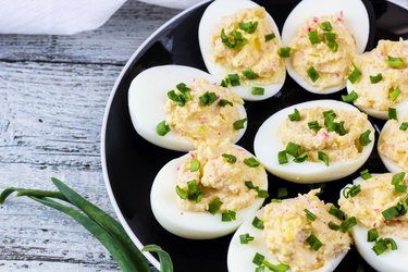 Home eggs stuffed with cheese and crab topped with green onions