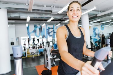 Young fit woman using an elliptic trainer