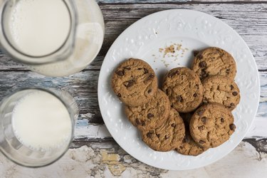 a plate of hard cookies and two glasses of milk