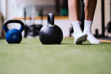 Man weight lifting in socks to improve exercise.