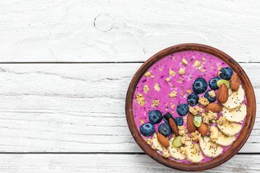 Healthy vegan breakfast. acai smoothie bowl with blueberry, fruits, granola, almonds, pumpkin and chia seeds