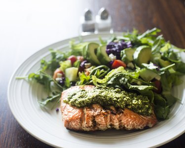 Salmon fillet topped with arugula pesto and salad