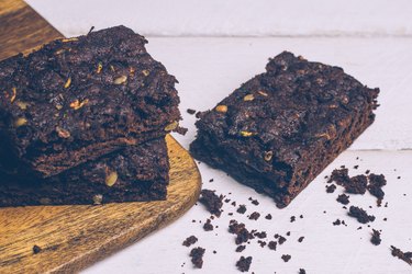 Vegan zucchini flourless paleo brownies and pumpkin brownies (keto, low carb and gluten-free) on a wooden background.