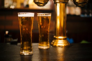 Glass of fresh and cold beer on wooden table