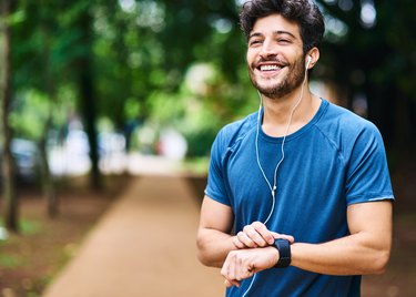 A smiling man checking his smartwatch after a job