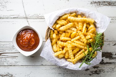 French fries with ketchup over old wooden table