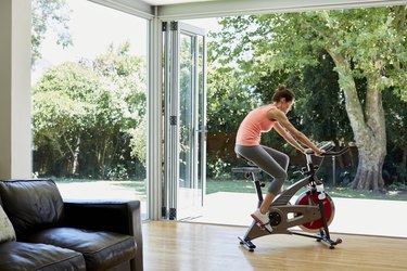Woman working out on exercise bike at home