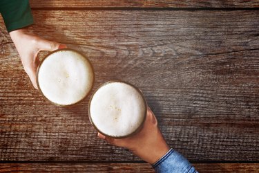 Cropped Hands With Beer On Table