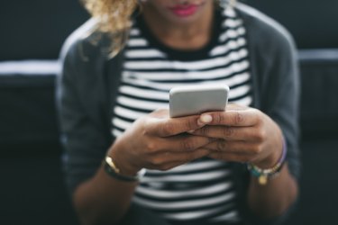 Woman wearing striped shirt holding smartphone