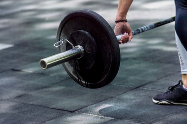 gym woman preparing for her weightlifting workout with a heavy dumbbell