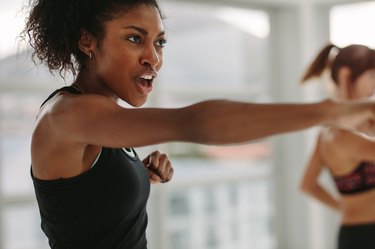 Women doing intense punching work out at the gym