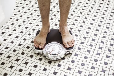 Adult man who takes Metformin standing on bathroom scales.