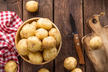 washed potato in a bowl on wooden table