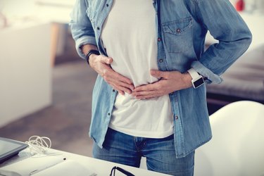 Close up of a man holding his stomach