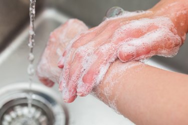 A man washing his hands with soap and water in a sink