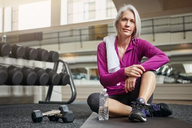 A woman over 60 losing weight by exercising at the gym