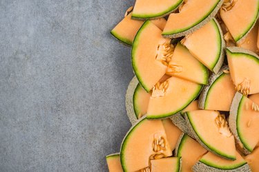 Cantaloupe melon slices, food border background