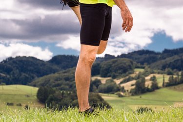 Male runner stretching outdoors at mountains background