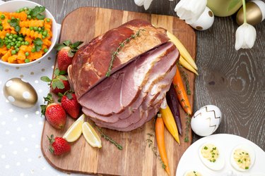 Ham on cutting board with carrots and strawberries