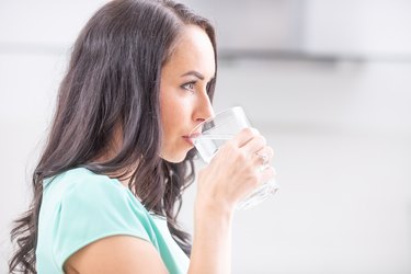 young woman drinks clean water adheres to drinking regimen