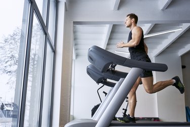 Man doing treadmill workout while looking out large window