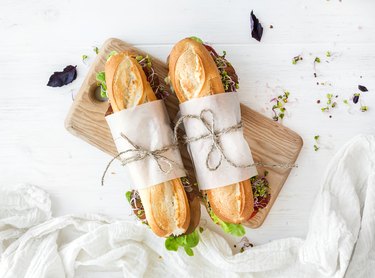 Sandwiches with beef, fresh vegetables and herbs on rustic wooden