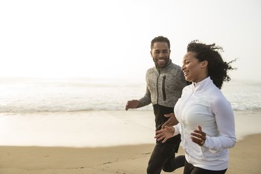 Man and woman running on the sand