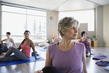 Women practicing seated twist pose in yoga class