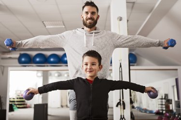 Father and son performing lateral raises.