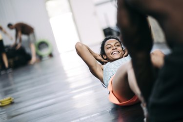 Young black girl doing crunches with her friend