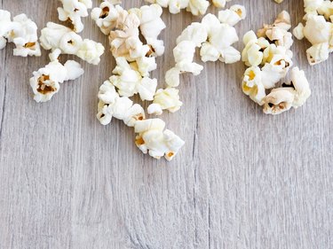 popcorn on wooden background, copy space, Scattered salted popcorn, texture background.