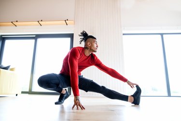 Man doing HIIT leg workout at home during halftime