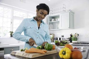 person prepping and pre-cooking vegetables in their kitchen the night before a holiday gathering cooking up a storm.