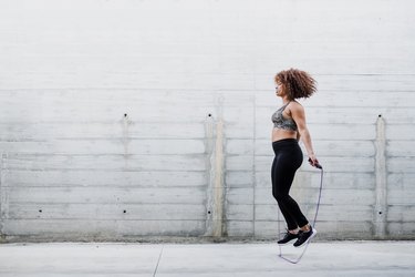 Curvy African American Woman Skipping Rope In Urban Area