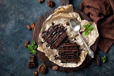 Chocolate brownie cake, dessert with nuts on dark background, directly above, flat lay