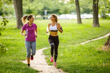 Young women running together in the park